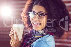 Smiling attractive hipster holding take-away cup