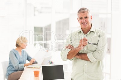 Standing smiling businessman looking at the camera