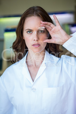 Serious optician holding up lens