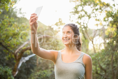 Smiling athletic brunette taking selfies