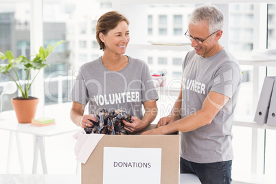 Smiling volunteers sorting donation box