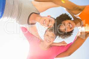 Sporty women with arms around smiling down to camera