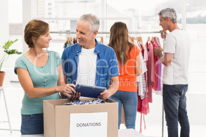 Smiling casual business colleagues with donation box