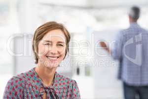 Smiling casual businesswoman in front of colleague