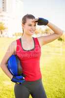 Smiling sporty blonde holding helmet