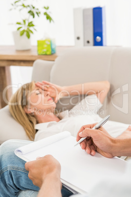 Depressed woman lying on couch and talking to therapist