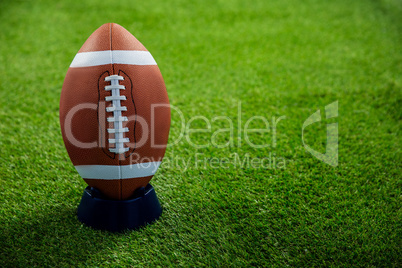 American football standing on holder