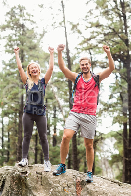 Happy young couple looking at camera with raised hands