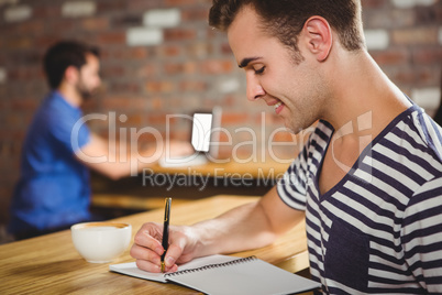 Young man taking notes in his notebook