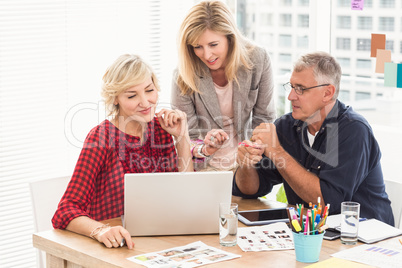 Smiling business team working over a laptop