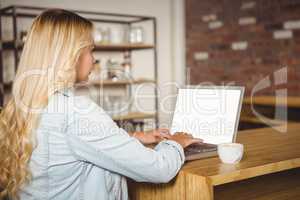 Rear view of blonde typing on laptop