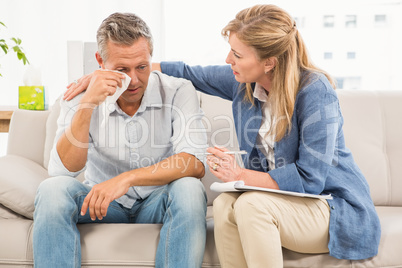 Concerned therapist comforting crying male patient