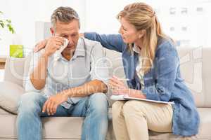 Concerned therapist comforting crying male patient
