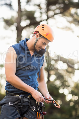 Handsome young hiker looking at his hooks