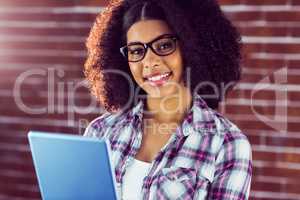 Attractive hipster smiling and holding tablet
