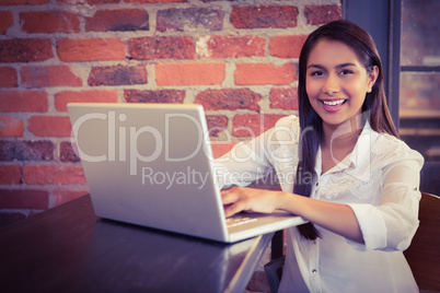 Businesswoman having coffee and working on laptop