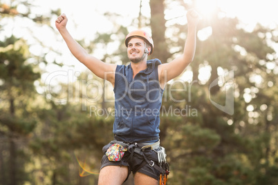 Handsome young hiker looking away and cheering