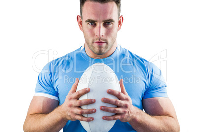 Rugby player looking at camera with ball