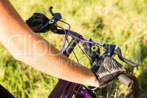 Woman mountain biking and holding handlebars