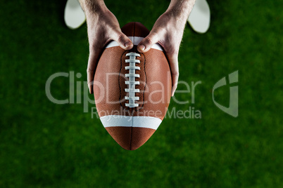 American football player holding up football