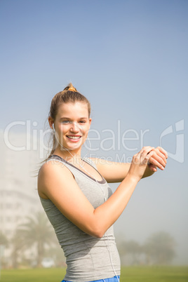 Smiling sporty blonde using smart watch