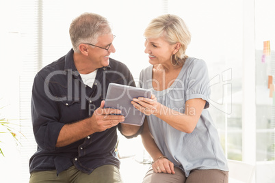 Smiling business team working over a tablet