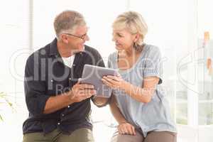 Smiling business team working over a tablet