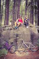 Young happy biker couple sitting on a rock