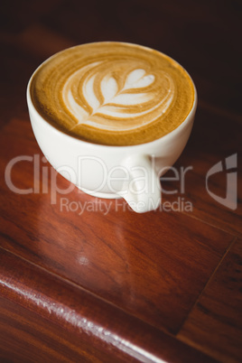 Cup of cappuccino with coffee art on the counter