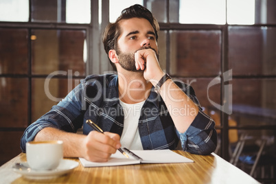 Young man taking notes in his notebook