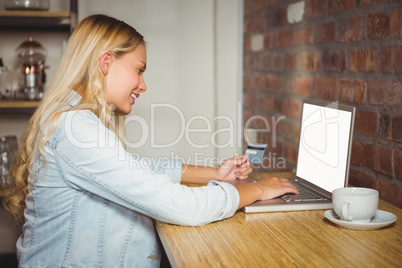 Smiling blonde doing online shopping