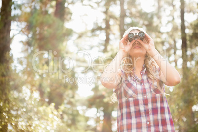 Pretty young blonde looking through binoculars