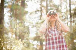 Pretty young blonde looking through binoculars