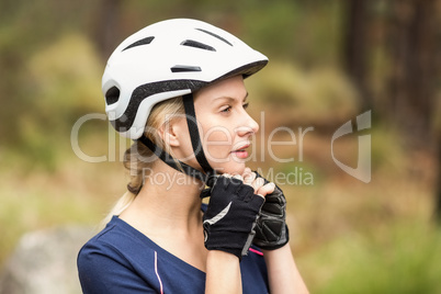 Young pretty happy biker taking off helmet