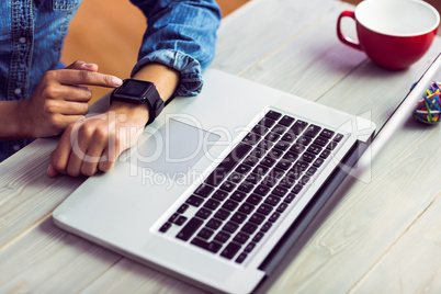 Casual businesswoman using her smart watch