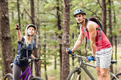 Young happy couple on bikes looking away