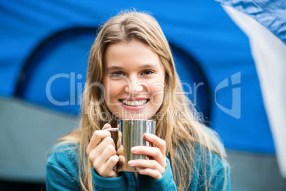 Portrait of a young pretty hiker sitting in a tent