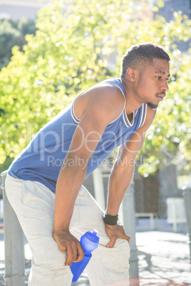 An handsome athlete holding a bottle