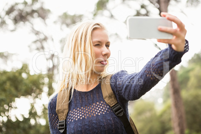 Smiling female hiker taking a funny selfie