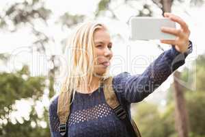 Smiling female hiker taking a funny selfie