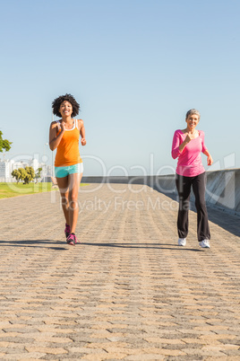 Two sporty women jogging together