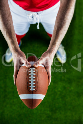 American football player holding up football