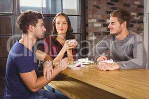 Friends talking and enjoying coffee and cake