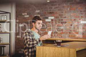Hipster having coffee and using smartphone