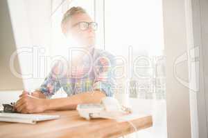 Casual designer sitting and daydreaming at his desk