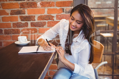 Smiling businesswoman having coffee and planning her week