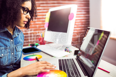 Casual female designer using laptop