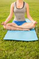Sporty woman meditating on exercise mat
