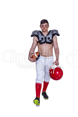 American football player walking with a ball and helmet