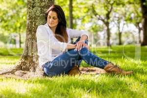 Beautiful brunette relaxing in the park